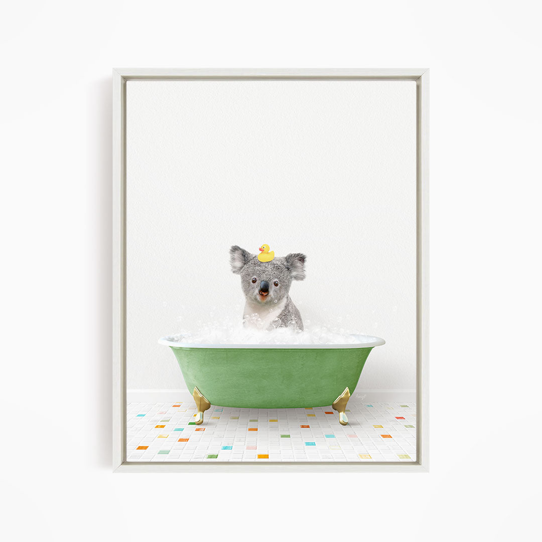 A koala bear sitting in a green bathtub filled with bubbles, wearing a yellow rubber duck hat.