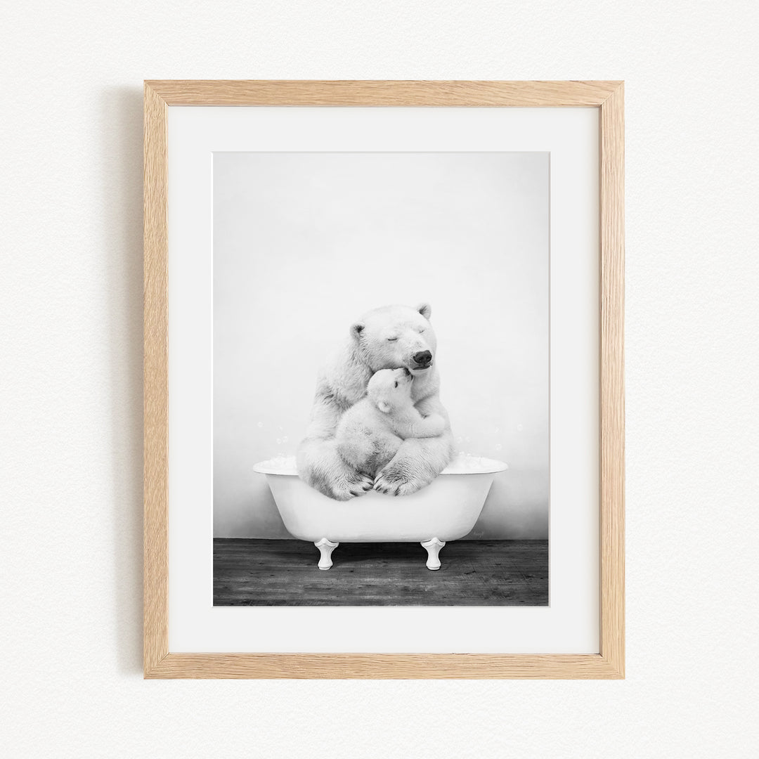 A black and white photograph of two polar bears sitting in a bathtub, with one bear appearing to be hugging the other.