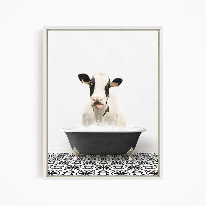 A black and white cow is sitting in a black bathtub filled with water, appearing to enjoy the bath.