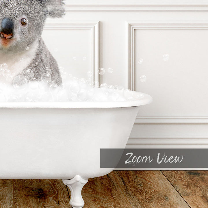 A koala sitting in a white bathtub filled with bubbles, as if enjoying a bath.