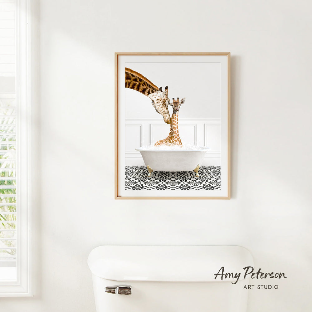 A framed image of two giraffes sitting in a bathtub, with one giraffe appearing to be licking the other.