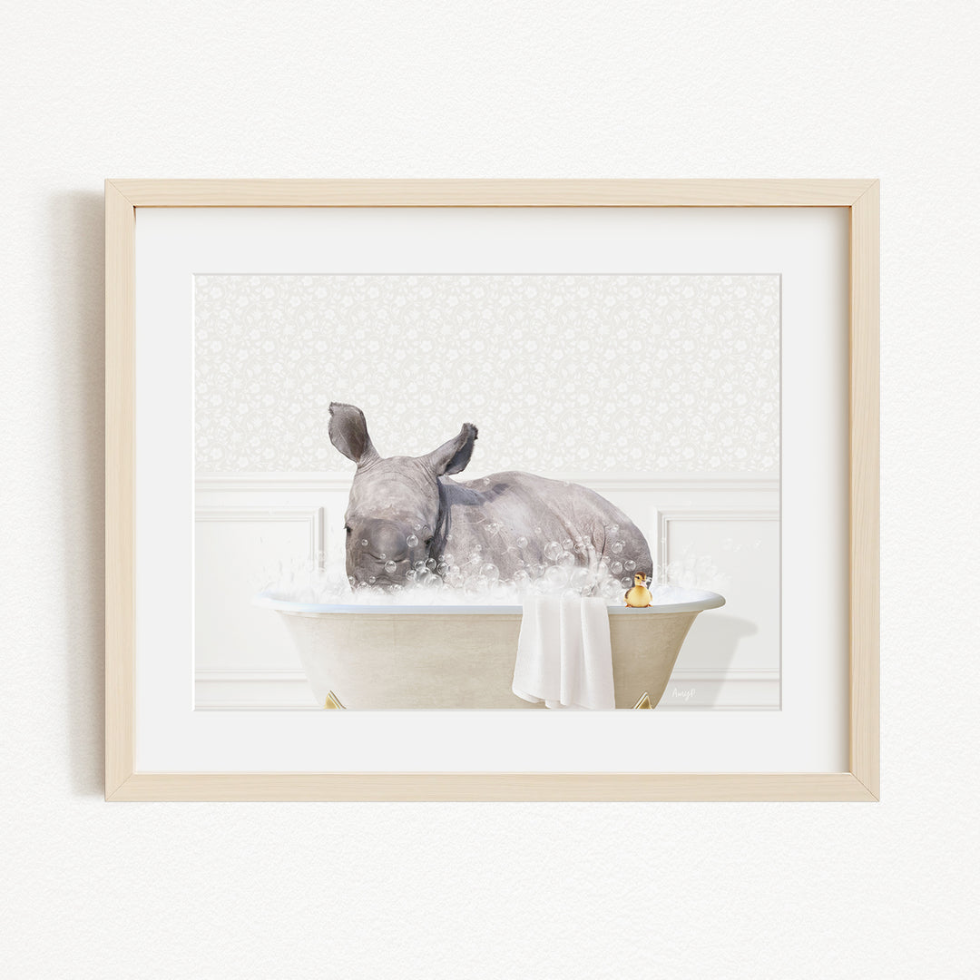 A rhinoceros is sitting in a bathtub filled with water, surrounded by bubbles, in a white-walled room.