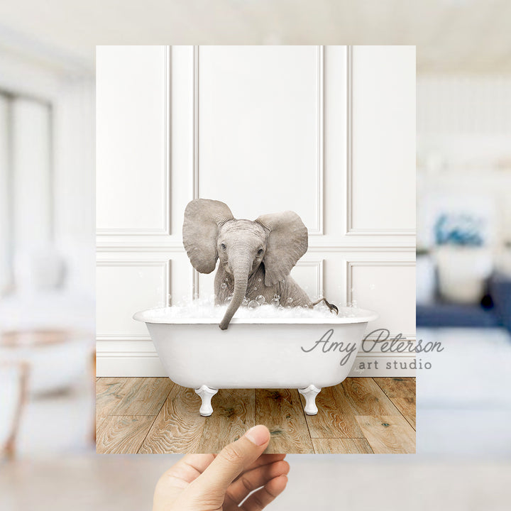 a hand holding a photo of an elephant in a bathtub