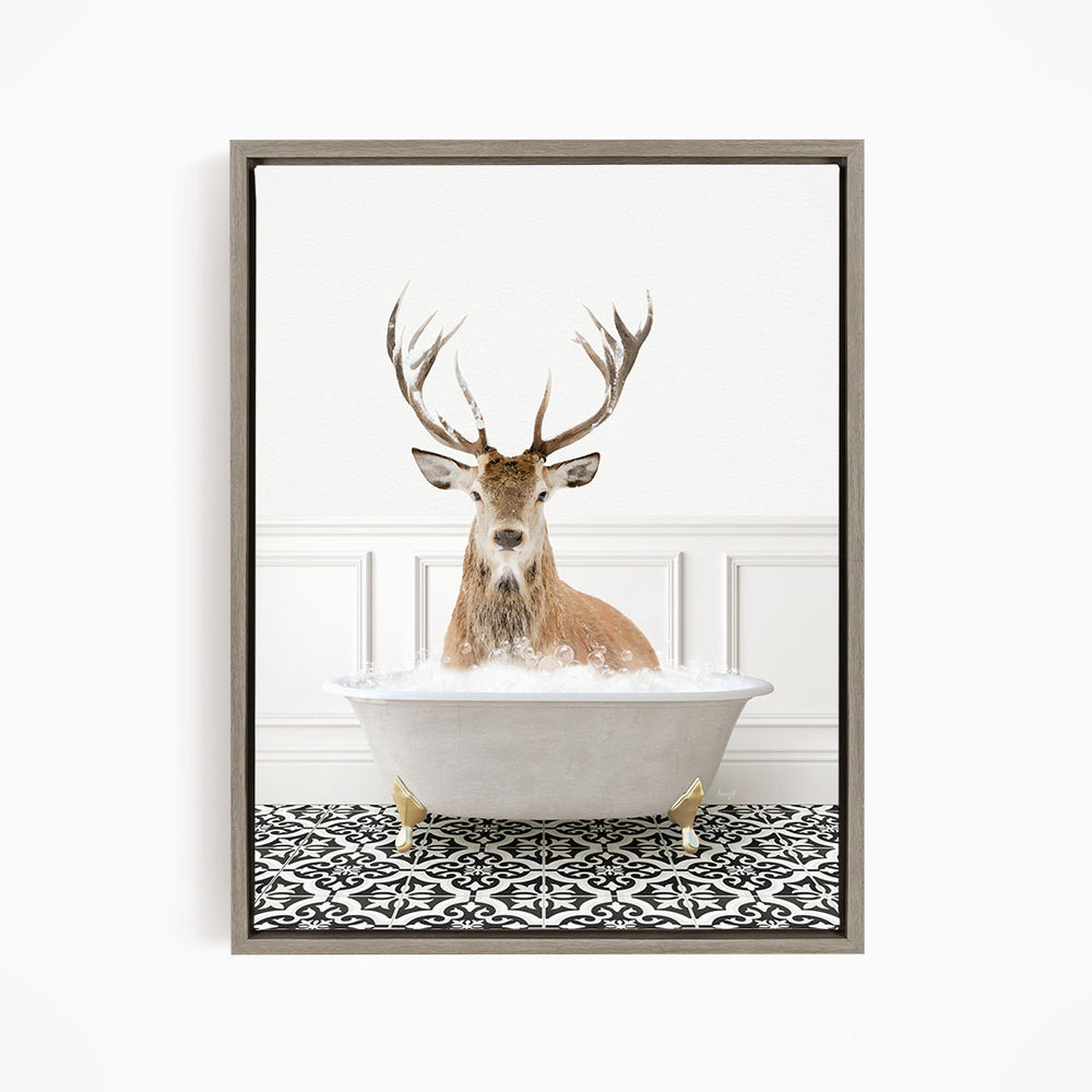 A deer with large antlers is sitting in a white bathtub filled with water, creating a whimsical and unexpected scene.
