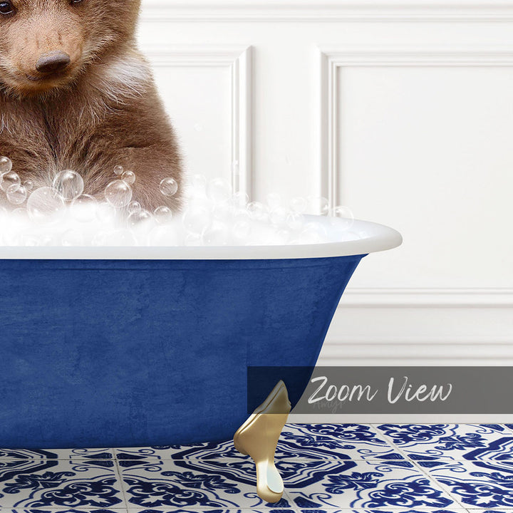 A brown bear is sitting in a blue bathtub filled with bubbles, with a white wall and a patterned tile floor in the background.
