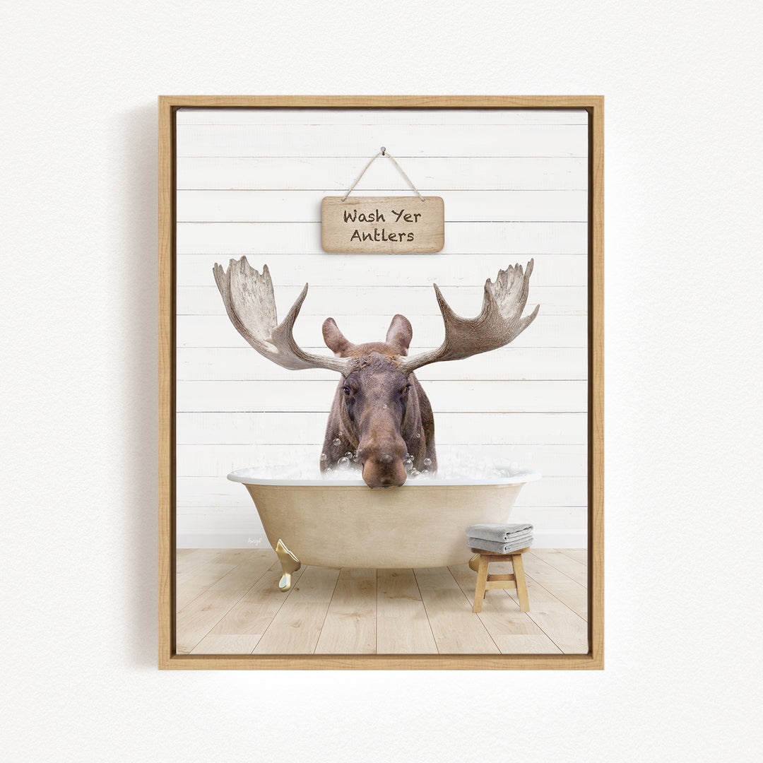 A moose is sitting in a bathtub, with a sign above it that says "Wash Yer Antlers".