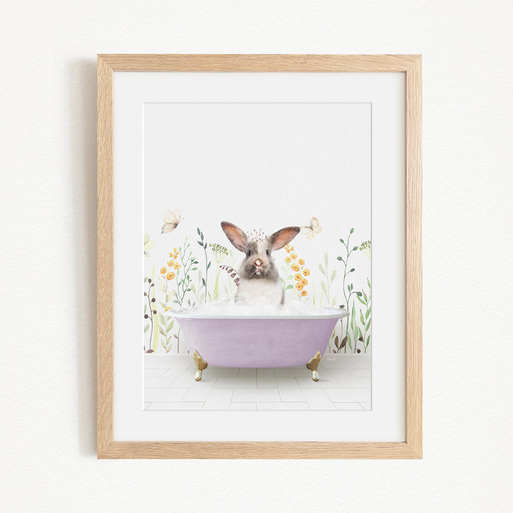 A framed print depicting a rabbit sitting in a purple bathtub filled with bubbles, surrounded by flowers and butterflies.