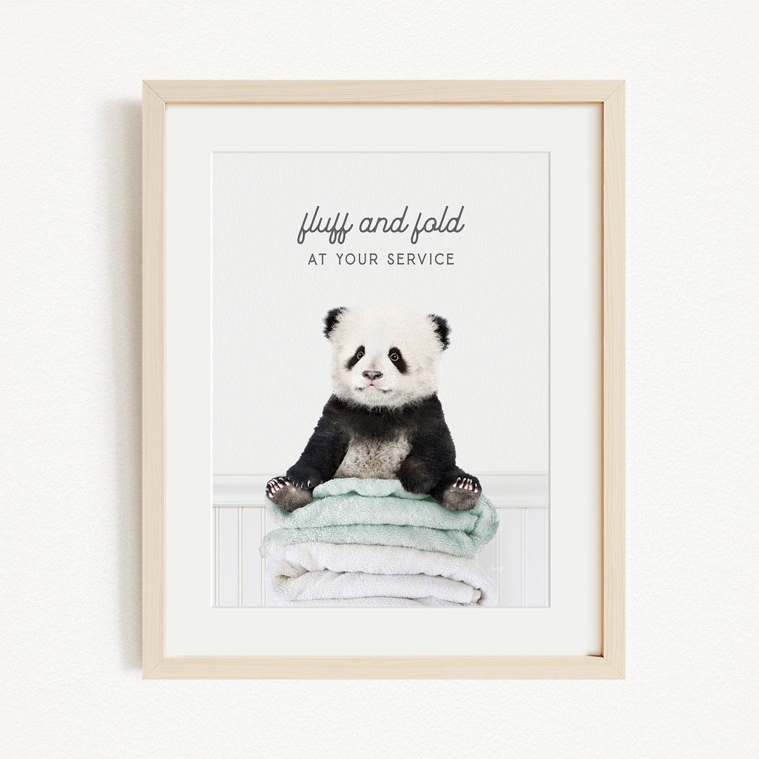A panda bear sitting on a stack of towels with the text "fluff and fold at your service" written above it.