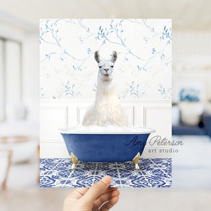 a llama sitting in a bathtub with a hand holding up a card