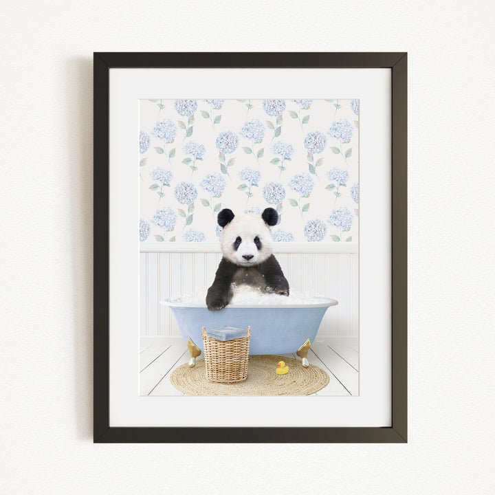 A panda bear sitting in a blue bathtub, surrounded by a floral patterned wall and a basket of rubber ducks.