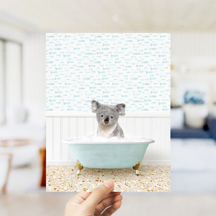 A koala bear sitting in a bathtub filled with bubbles, surrounded by a pattern of fish.