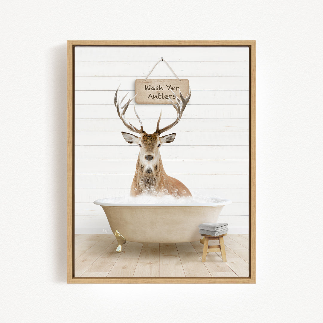 A deer with antlers is sitting in a bathtub filled with water, with a sign above it that says "Wash Yer Antlers".