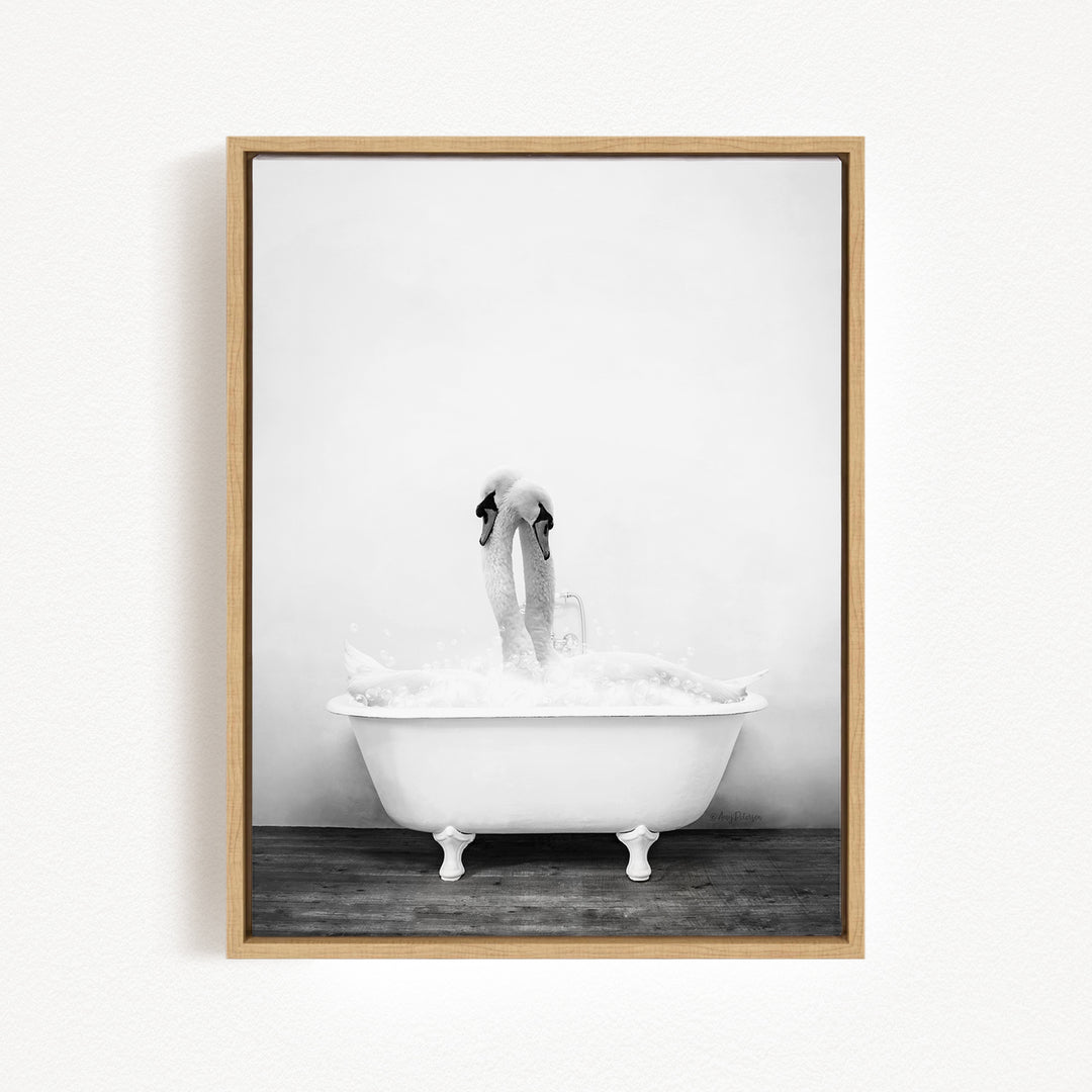 A black and white photograph of a swan standing in a bathtub filled with water, creating a whimsical and playful scene.