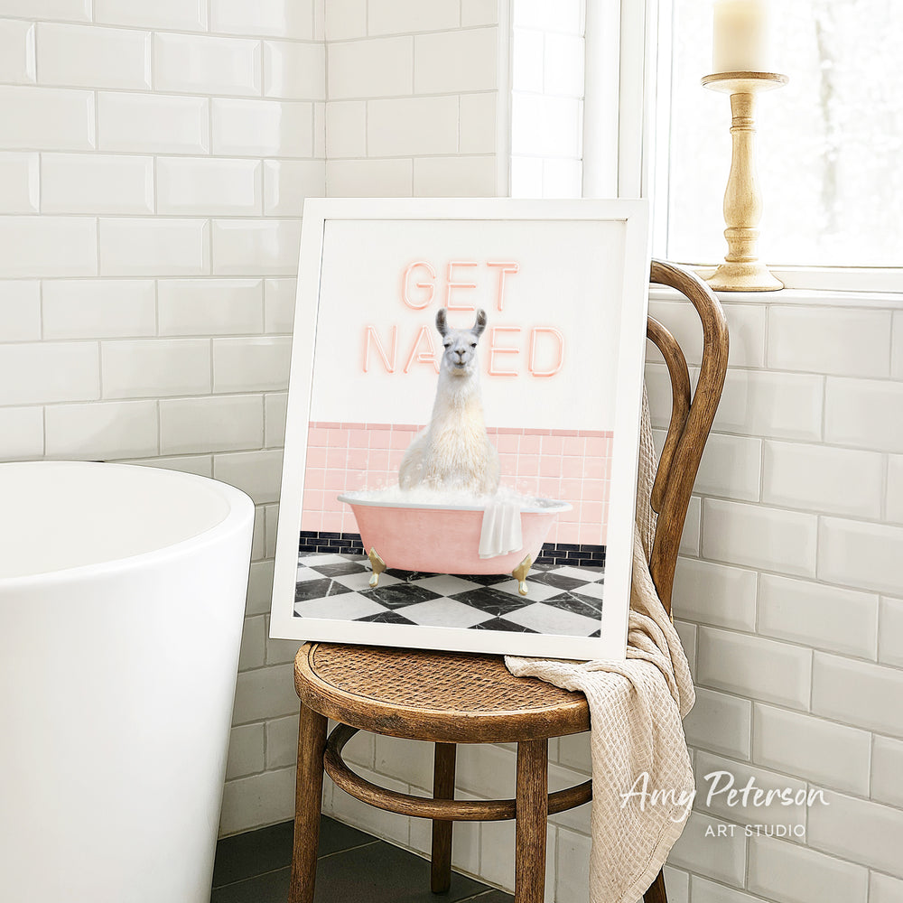 A framed image of a white llama sitting in a pink bathtub, with the text "GET NAUGED" displayed on the frame.