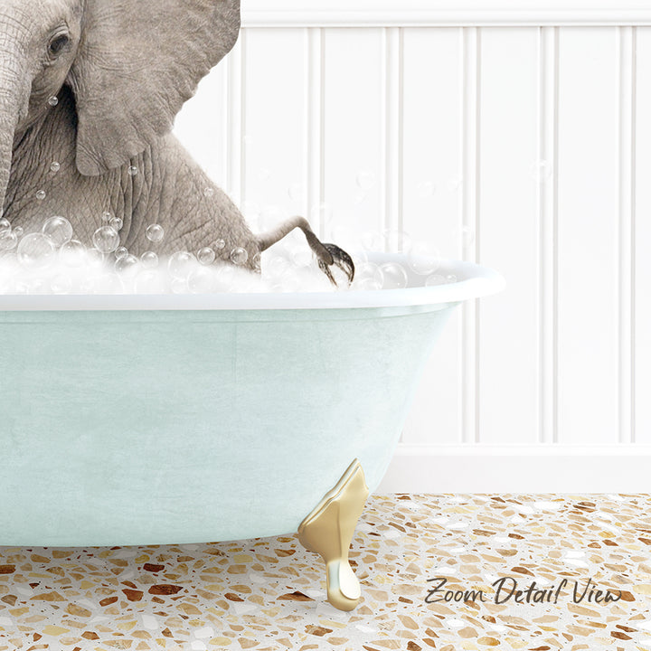 A gray elephant is sitting in a light blue bathtub filled with bubbles, with its trunk submerged in the water.