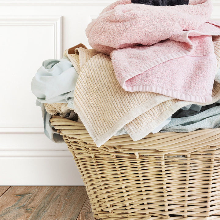 a wicker basket filled with a pile of clothes