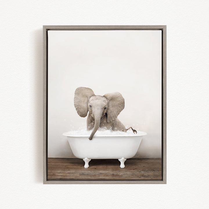 A baby elephant sitting in a white bathtub filled with water, with its trunk submerged in the water.