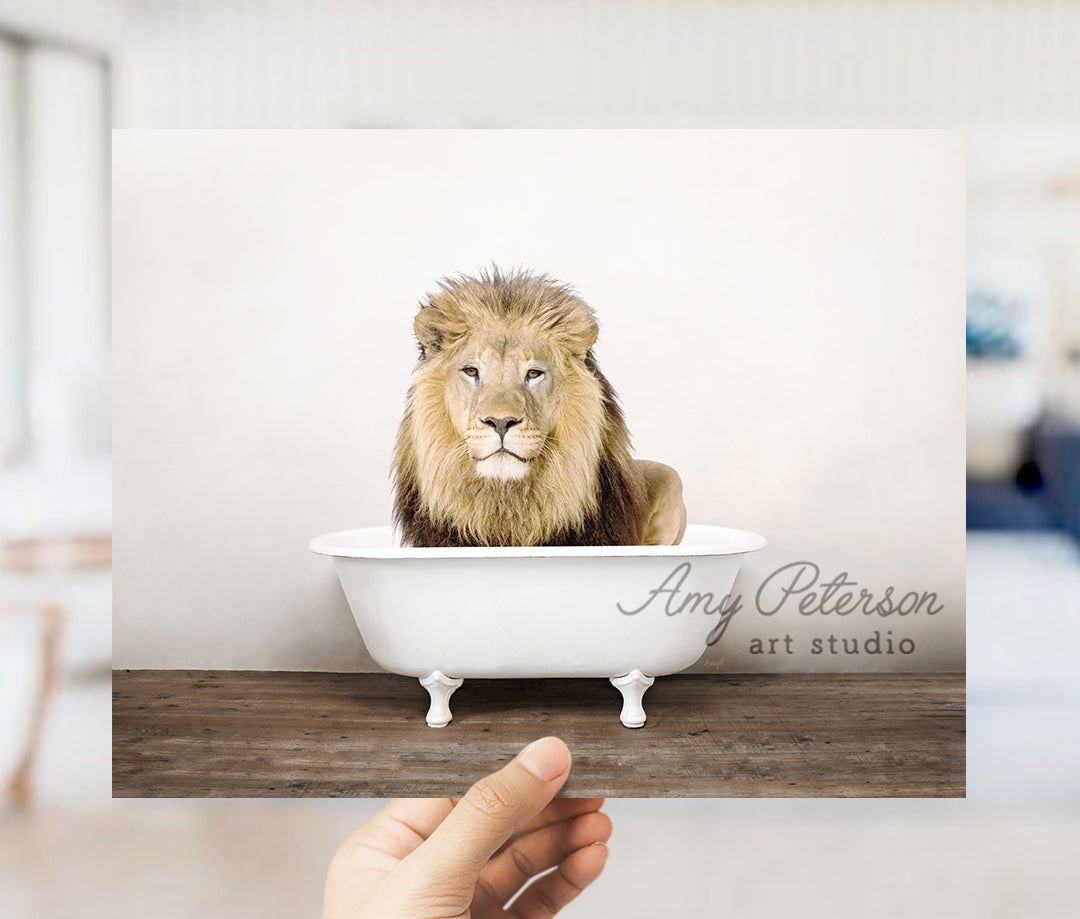 a hand holding a card with a picture of a lion in a bathtub