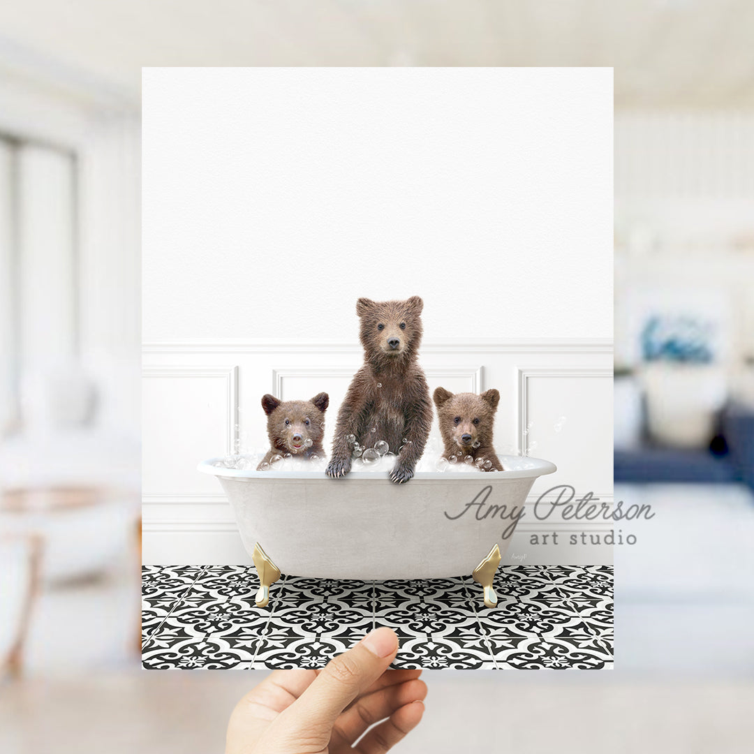 a hand holding a card with three bears in a bathtub