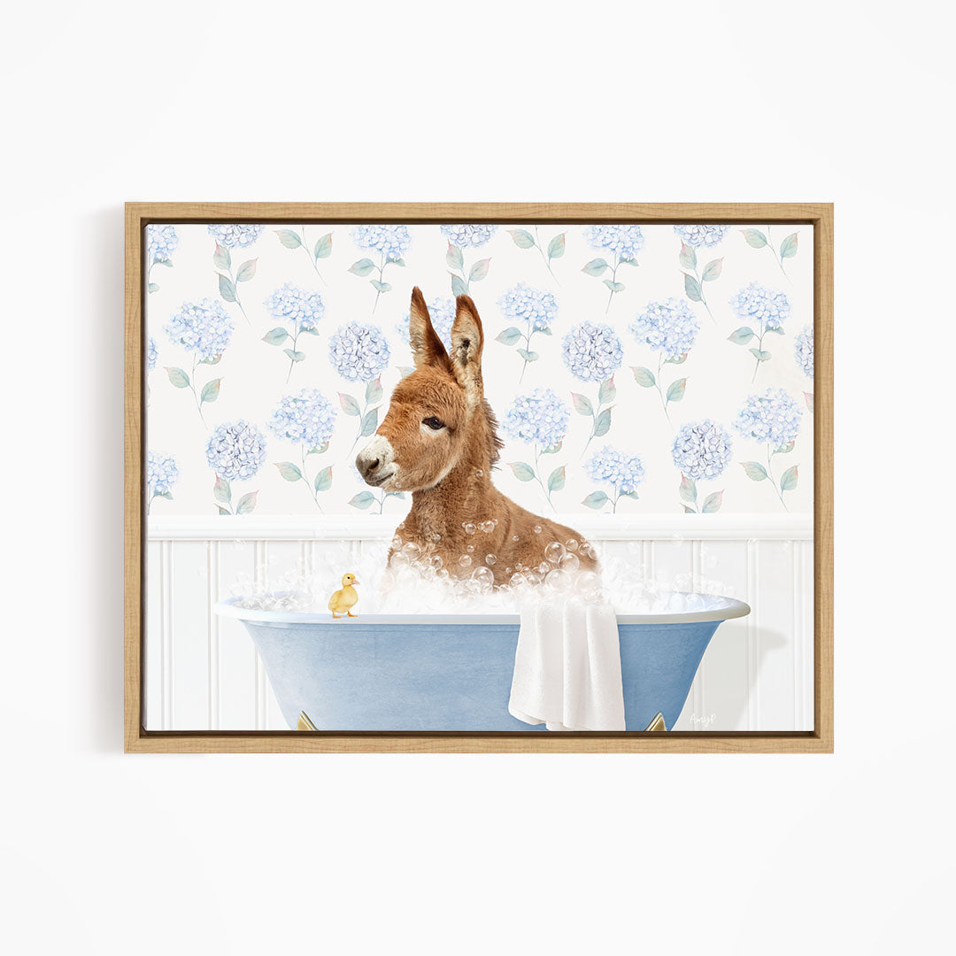 A brown dog is sitting in a blue bathtub filled with bubbles, with a yellow duck sitting on the edge of the tub.