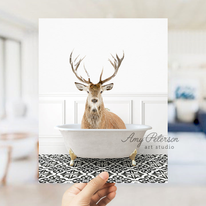 a hand holding a card with a picture of a deer in a bathtub