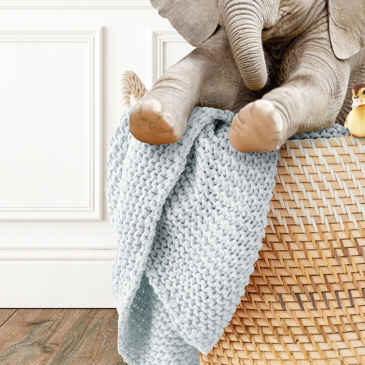 a stuffed elephant sitting on top of a basket