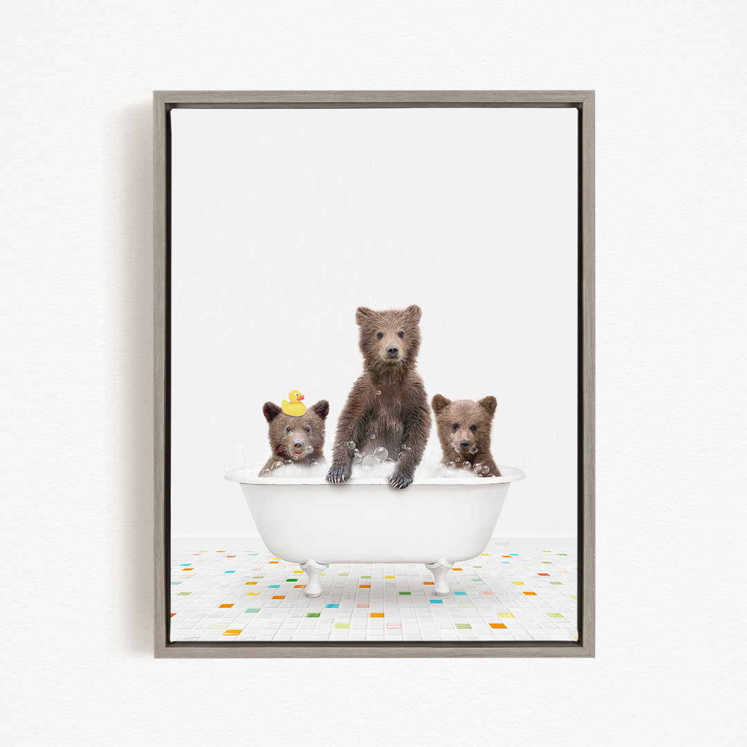 A framed image depicting three bears sitting in a white bathtub filled with water, with one bear sitting on the edge of the tub and the other two bears sitting inside the tub.