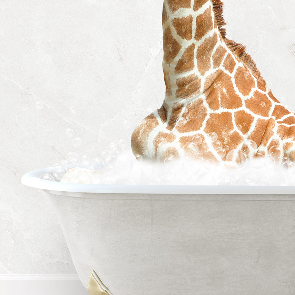 a giraffe laying down in a bathtub filled with foam