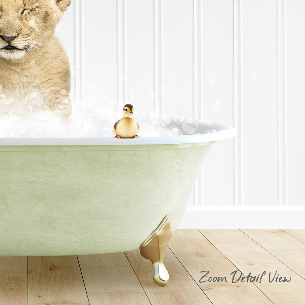 A lion cub is taking a bath in a green bathtub, with a small yellow duck sitting on the edge of the tub.