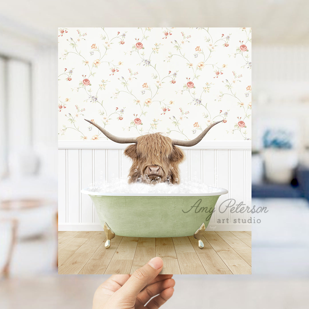 a hand holding up a photo of a bull in a bathtub