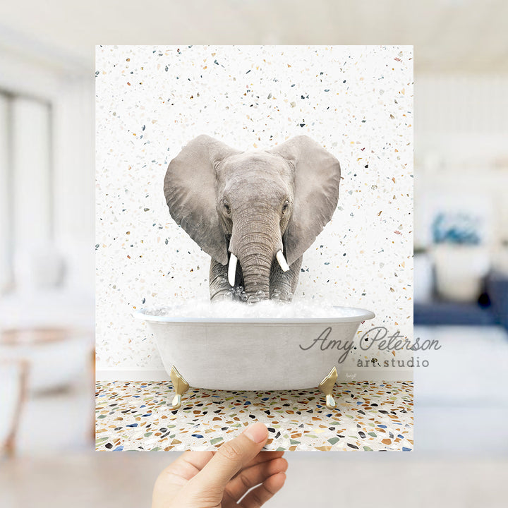 a person holding up a picture of an elephant in a bathtub