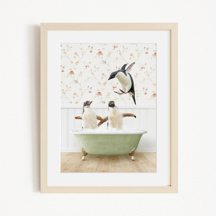 A framed image depicting two penguins sitting in a green bathtub, with one penguin standing on its hind legs and the other sitting comfortably.