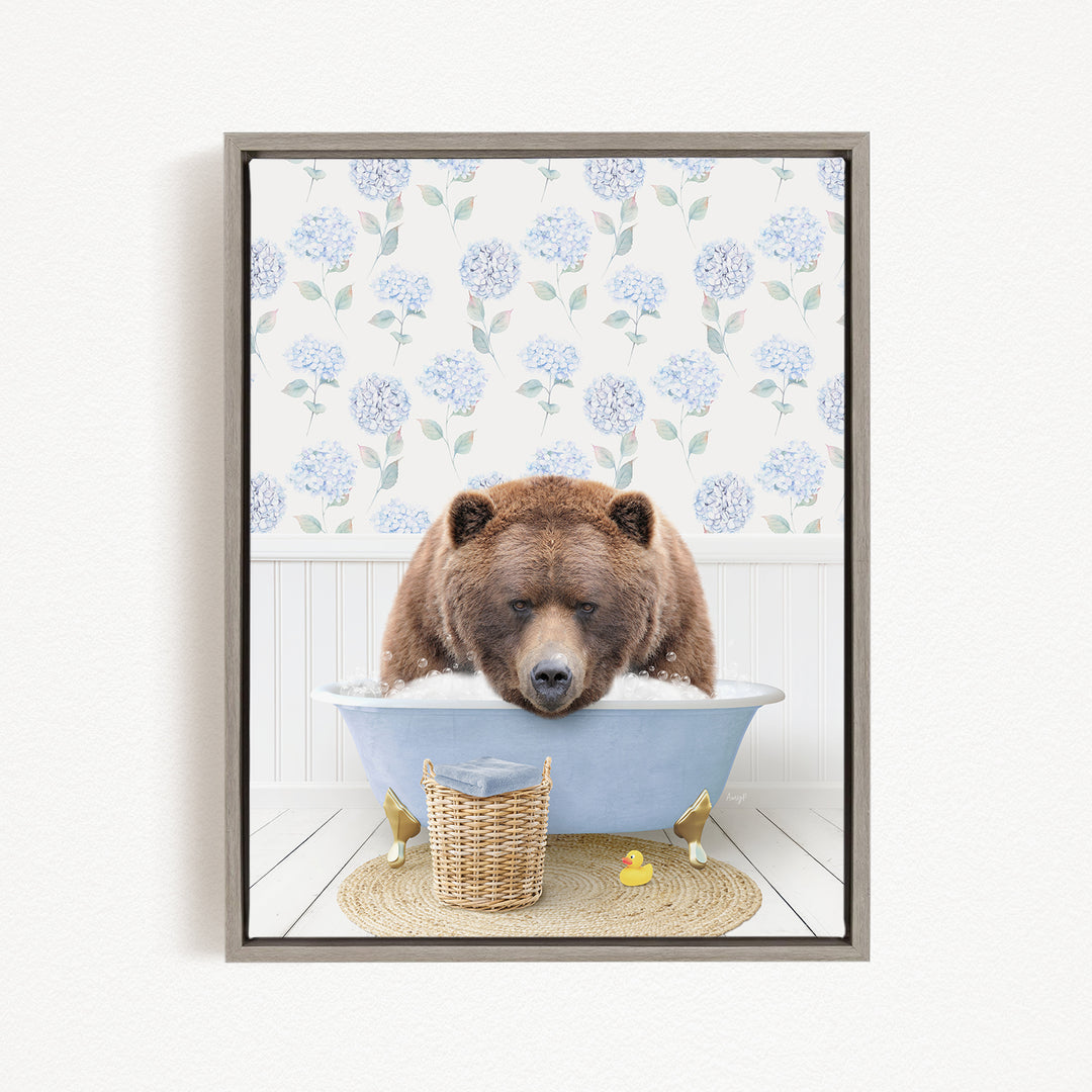 A brown bear is sitting in a blue bathtub filled with water, surrounded by a wicker basket and a rubber duck.