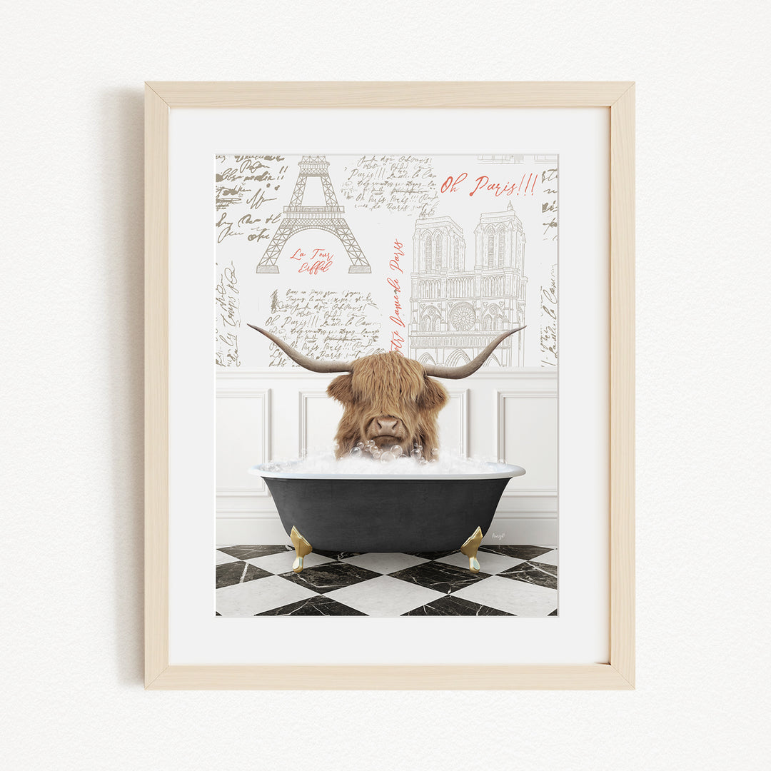 A framed image depicting a Highland cow sitting in a bathtub, with a Paris-themed background featuring the Eiffel Tower and other Parisian landmarks.