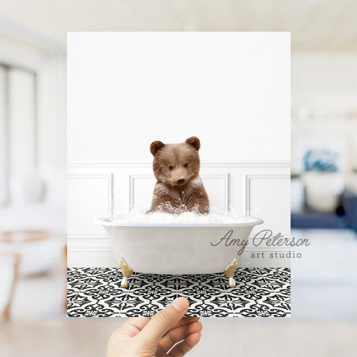 a person holding up a polaroid picture of a teddy bear in a bathtub