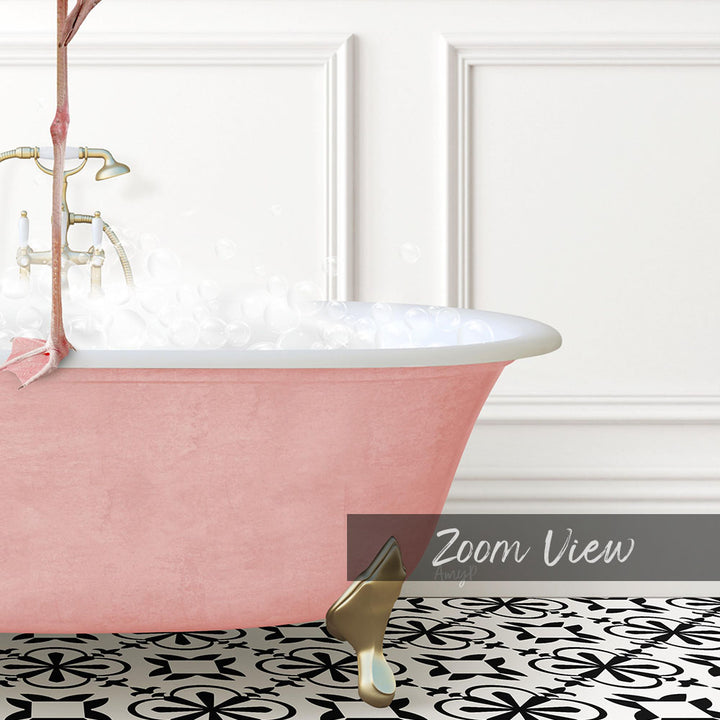 A pink claw-foot bathtub filled with bubbles, set against a white wall with a black and white patterned floor.