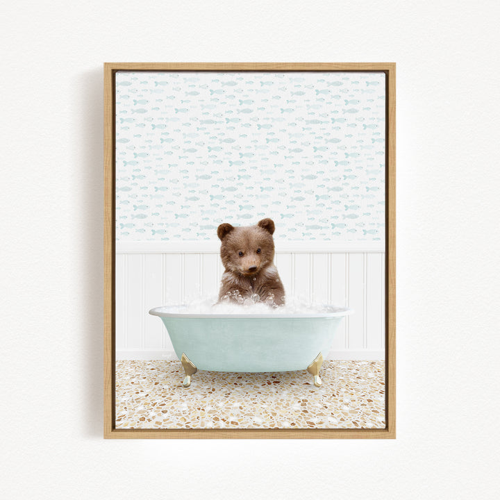 A cute brown bear sitting in a light blue bathtub filled with bubbles, surrounded by a patterned wall and a tiled floor.