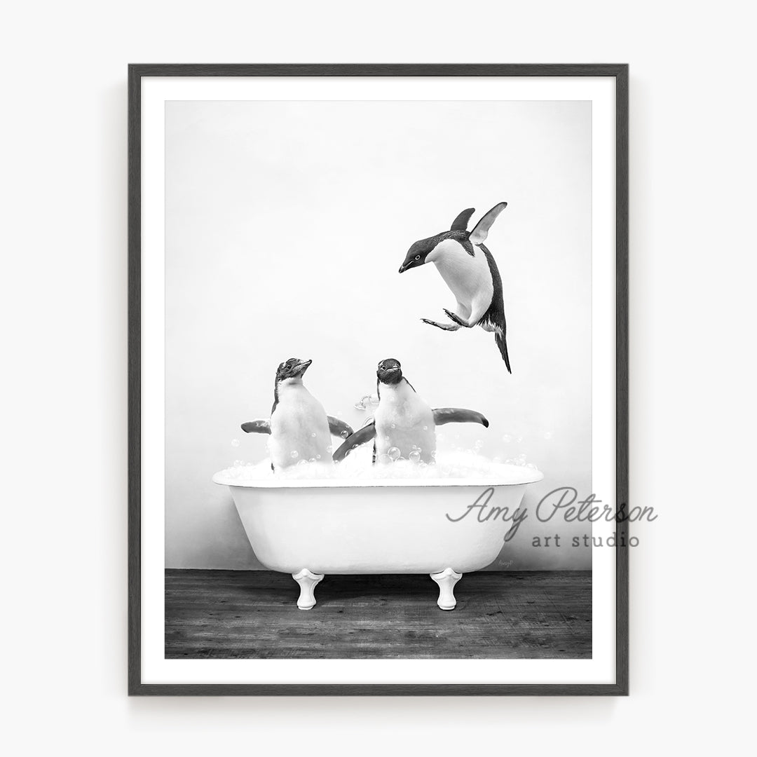 a black and white photo of three penguins in a bathtub