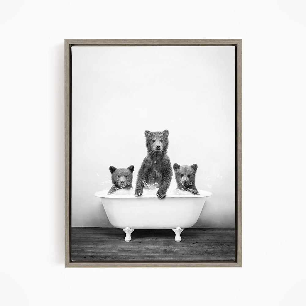 A black and white image of three bears sitting in a bathtub.