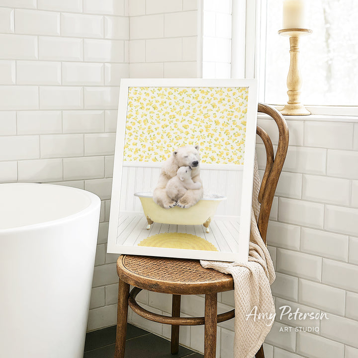 A framed image of two polar bears sitting in a bathtub, with a yellow floral pattern on the wall behind them.