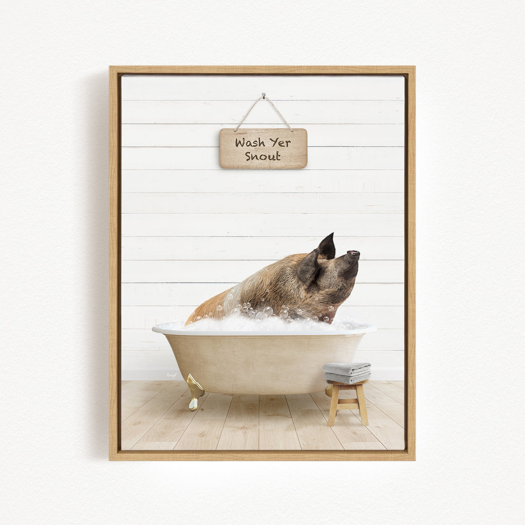 A brown dog is sitting in a white bathtub filled with bubbles, with a wooden sign above that reads "Wash Yer Shout".