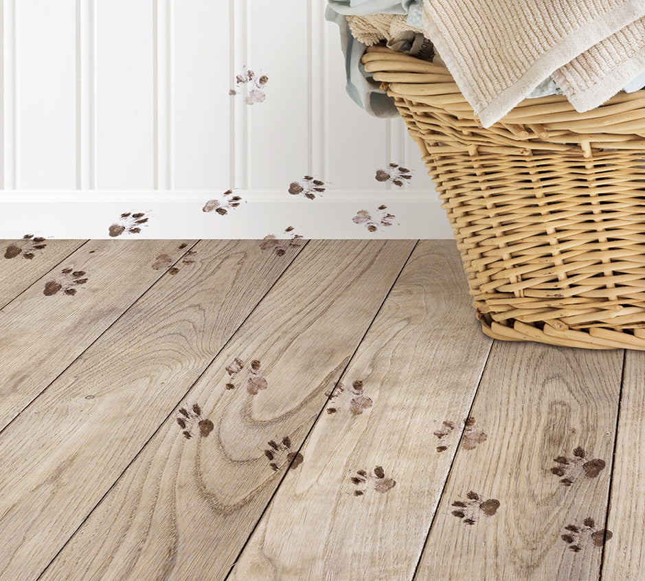 a basket with a towel and paw prints on the floor