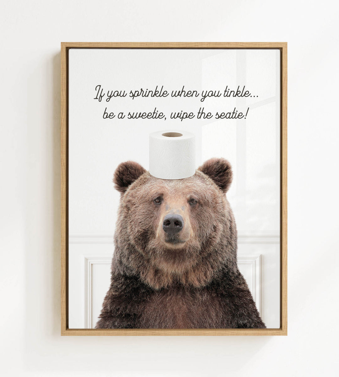 A brown bear sitting on top of a roll of toilet paper, with a humorous caption below the image.