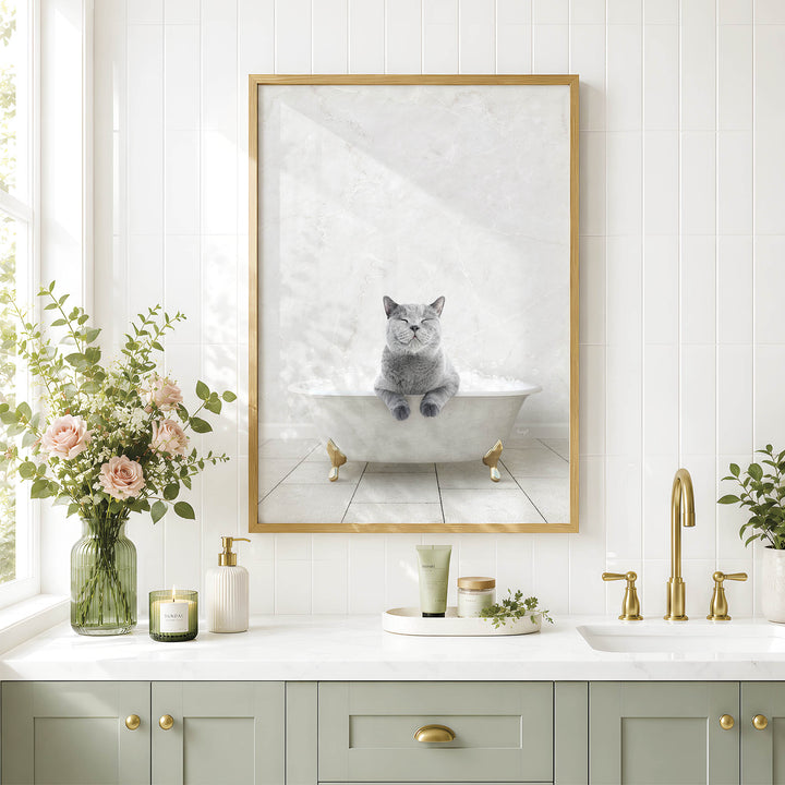 A framed image of a cat sitting in a bathtub, surrounded by a vase of flowers, candles, and a potted plant, all set against a white tiled wall.