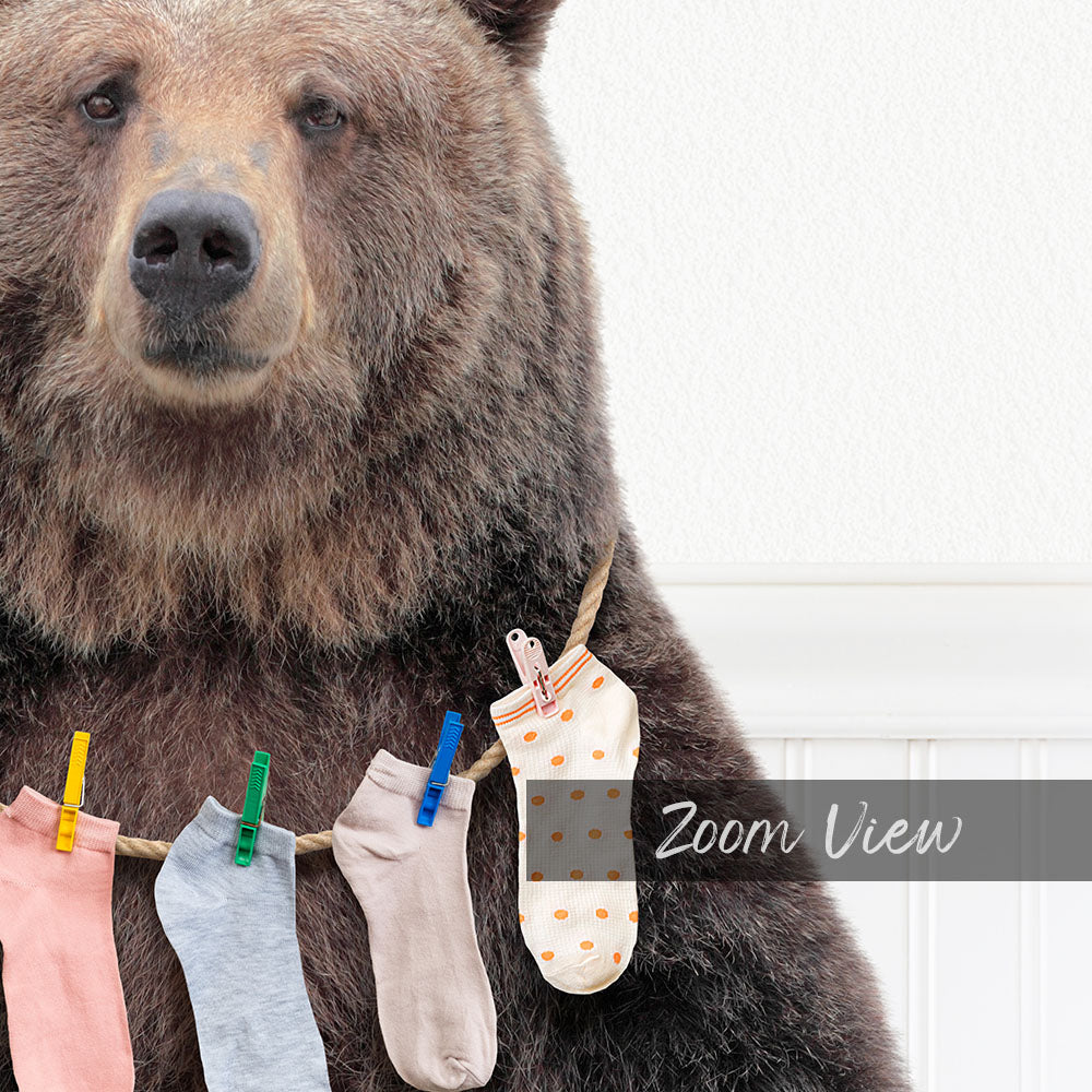 A large brown bear wearing a clothesline with colorful socks hanging from it.