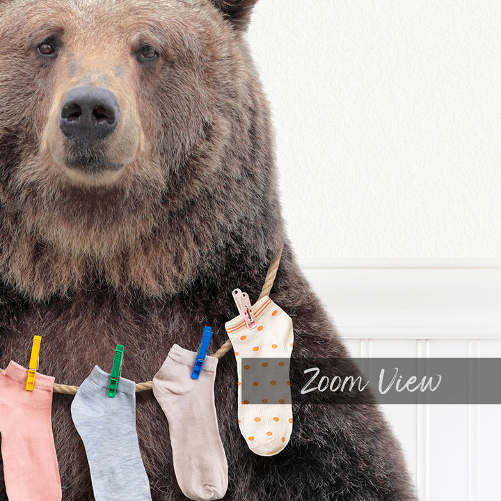 A large brown bear wearing a clothesline with colorful socks hanging from it.