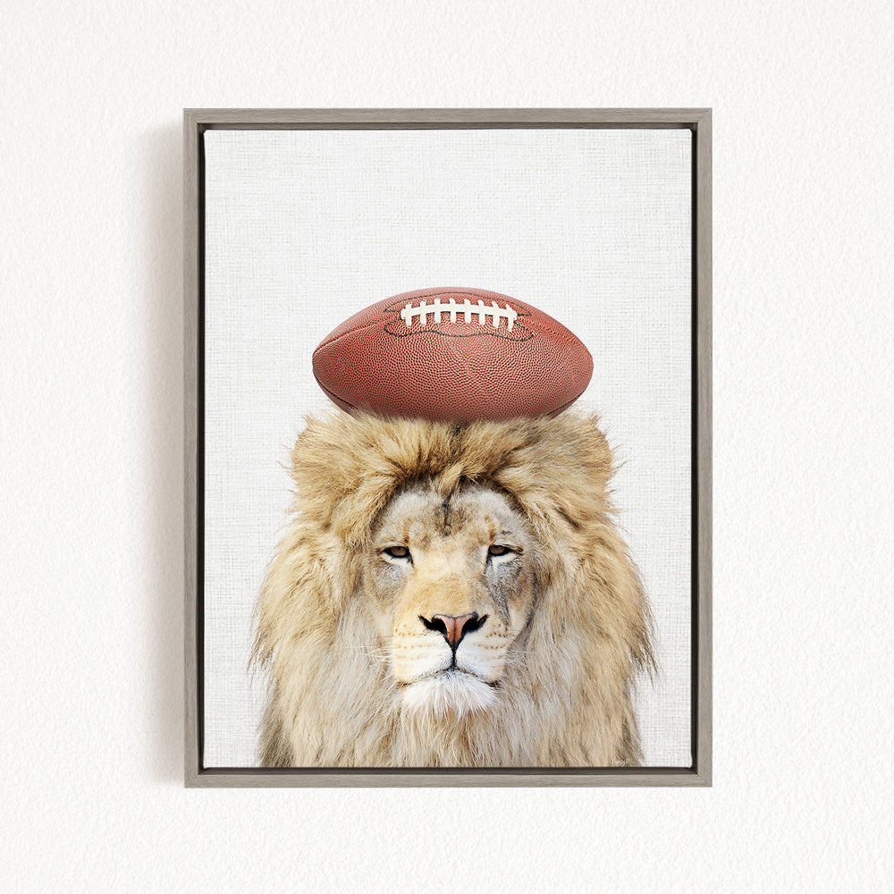 A lion with a football on its head, wearing a football helmet, is the main subject of the image.