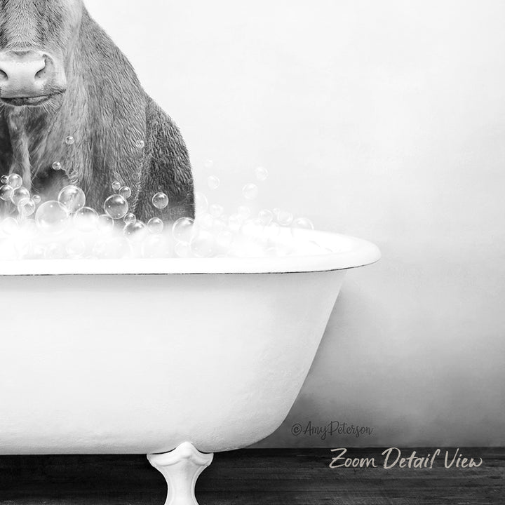 A black and white image of a cow standing in a bathtub filled with bubbles.