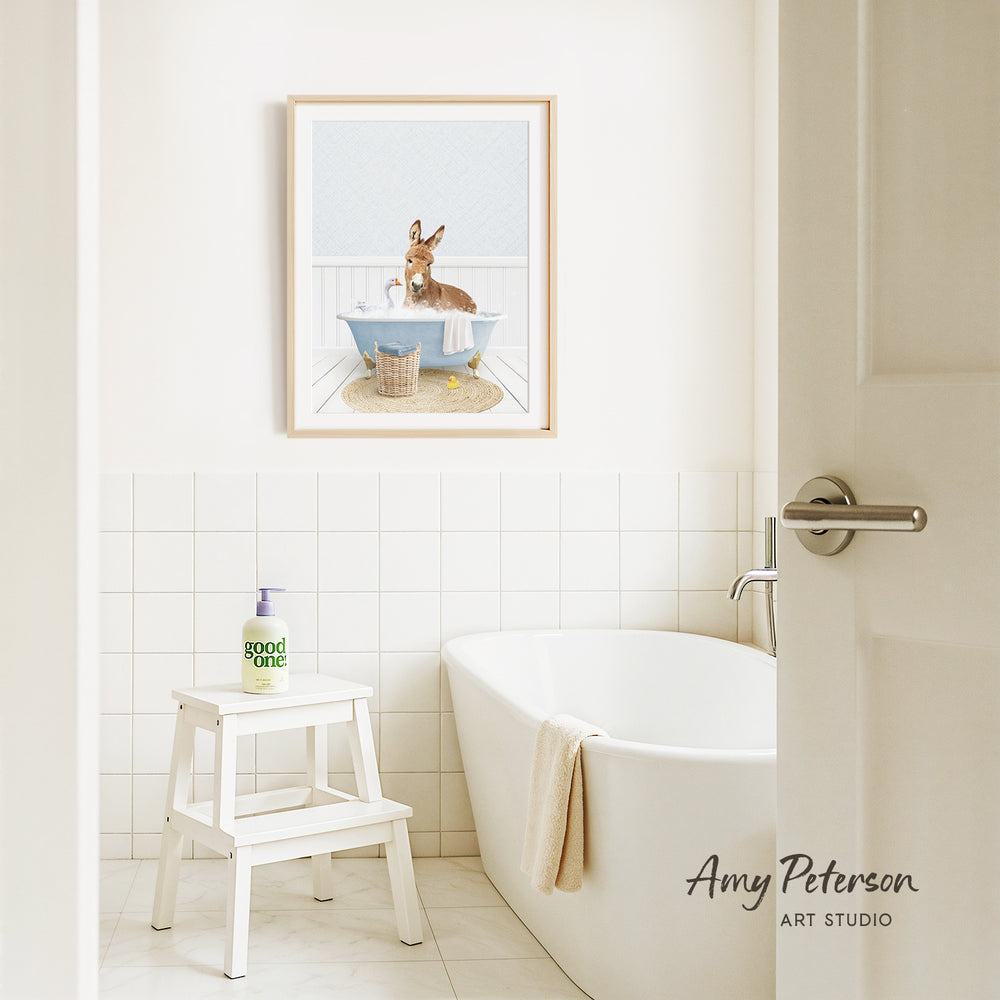 A bathroom with a white bathtub, a stool, and a framed picture of a dog sitting in a bathtub.