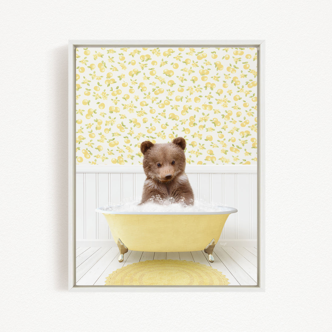 A cute brown bear sitting in a yellow bathtub filled with bubbles, surrounded by a yellow floral wallpaper.